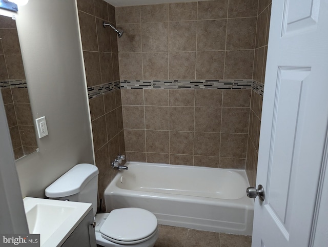 full bathroom featuring tiled shower / bath, vanity, toilet, and tile patterned flooring