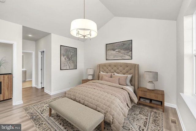 bedroom with wood-type flooring and vaulted ceiling