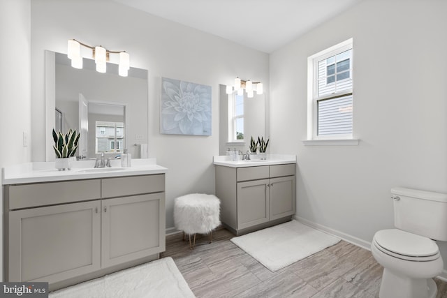 bathroom with toilet, hardwood / wood-style flooring, and vanity