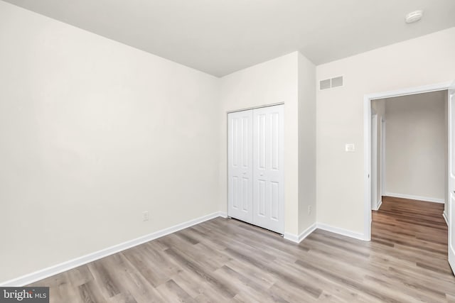 unfurnished bedroom with a closet and light wood-type flooring