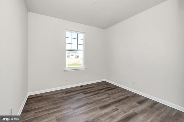 unfurnished room with dark wood-type flooring