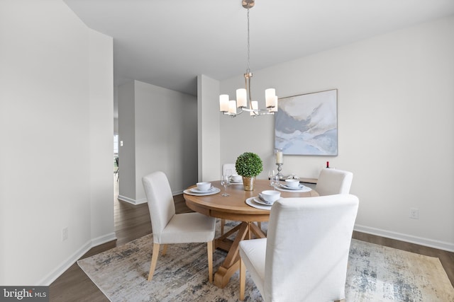 dining area featuring an inviting chandelier and dark hardwood / wood-style flooring