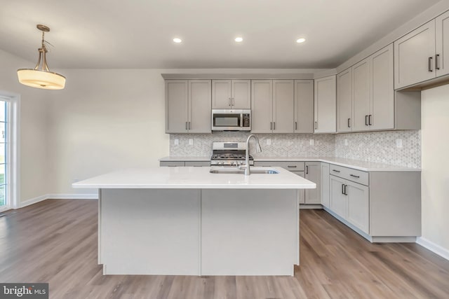 kitchen with gray cabinets, sink, hardwood / wood-style floors, and stainless steel appliances