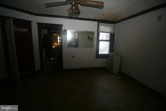 unfurnished room featuring radiator heating unit and ceiling fan