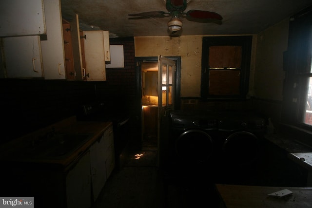 6659 N 20th St, Philadelphia, PA 19138 - kitchen with washing machine and clothes dryer, ceiling fan, white cabinetry, and range with electric stovetop