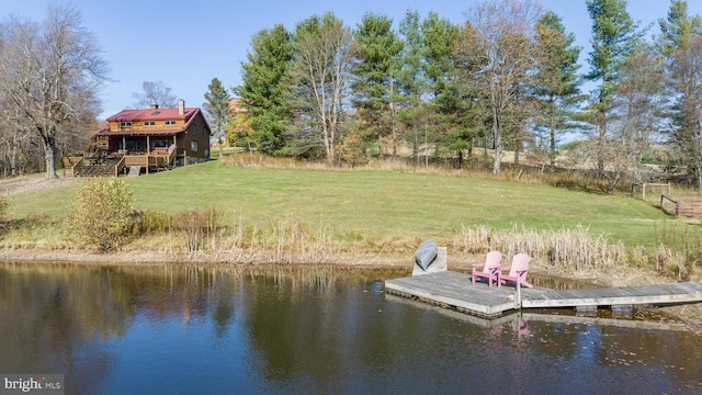 view of dock featuring a deck with water view and a lawn