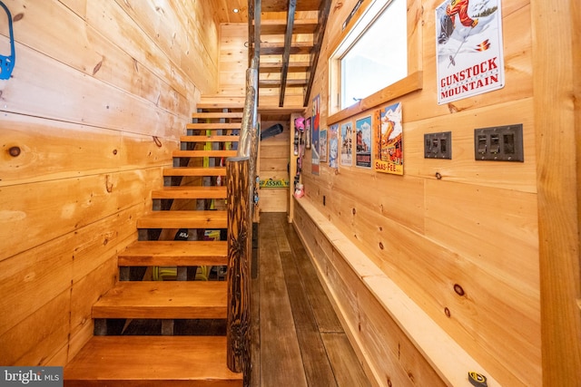 staircase featuring hardwood / wood-style flooring and wooden walls