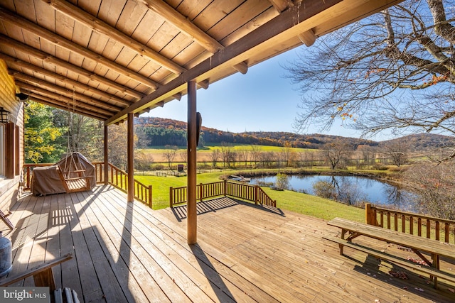 wooden deck featuring a water view and a yard