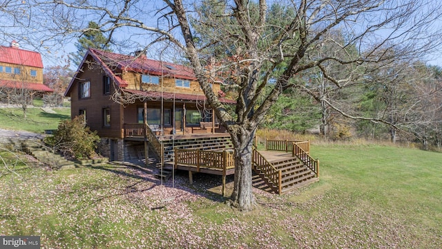 rear view of house featuring a lawn and a wooden deck