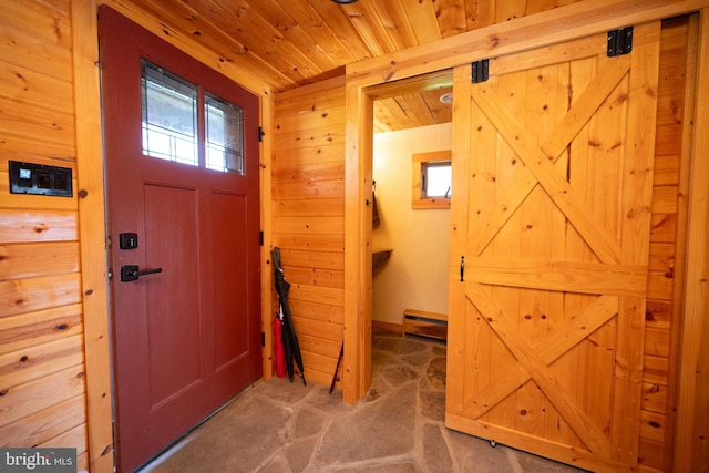 entrance foyer with carpet, a barn door, wood walls, wood ceiling, and baseboard heating