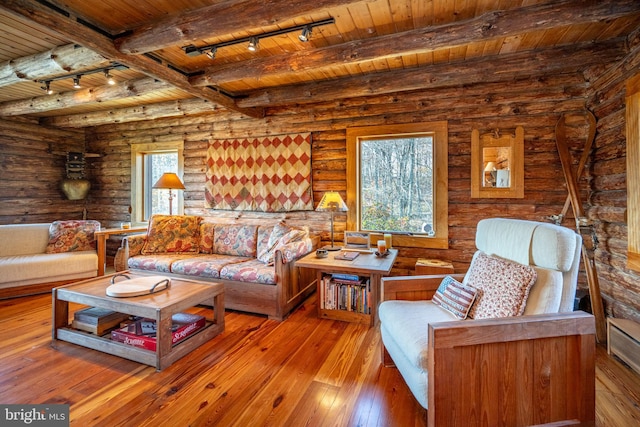 living room with rustic walls, hardwood / wood-style flooring, beam ceiling, and wooden ceiling