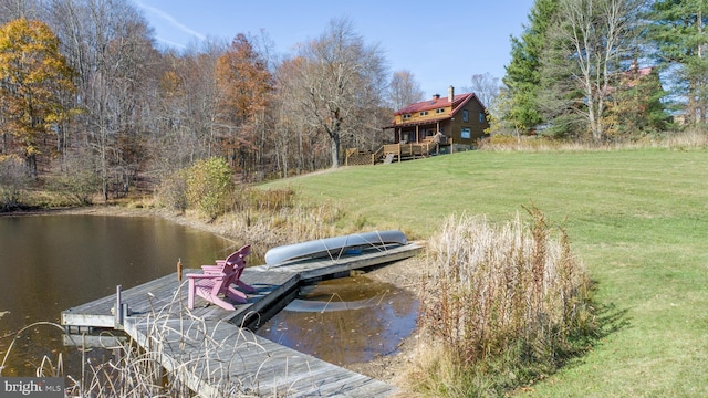 view of dock featuring a water view and a yard