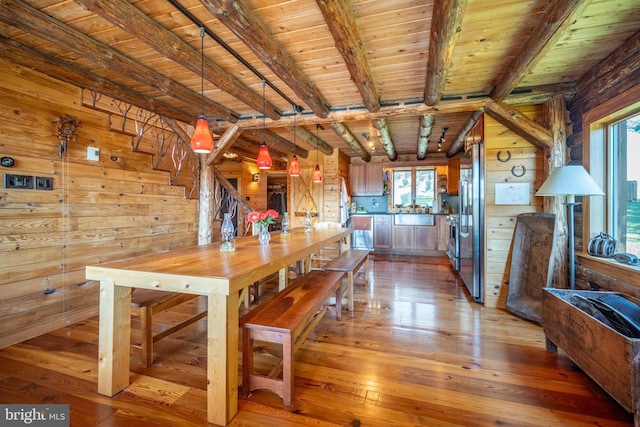 unfurnished dining area with a wealth of natural light, wooden walls, wood ceiling, and light hardwood / wood-style floors