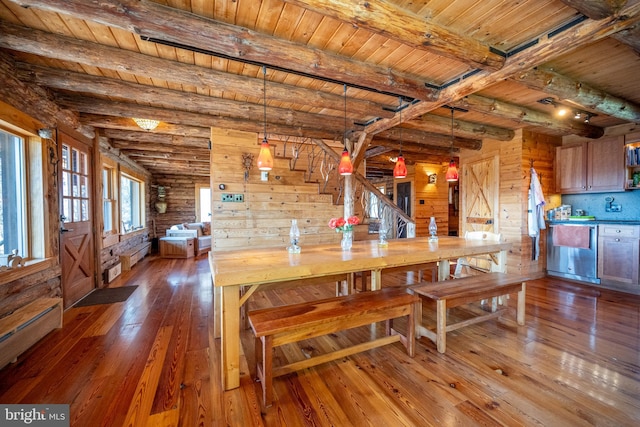 dining area with wood walls, beam ceiling, hardwood / wood-style floors, wood ceiling, and a baseboard radiator