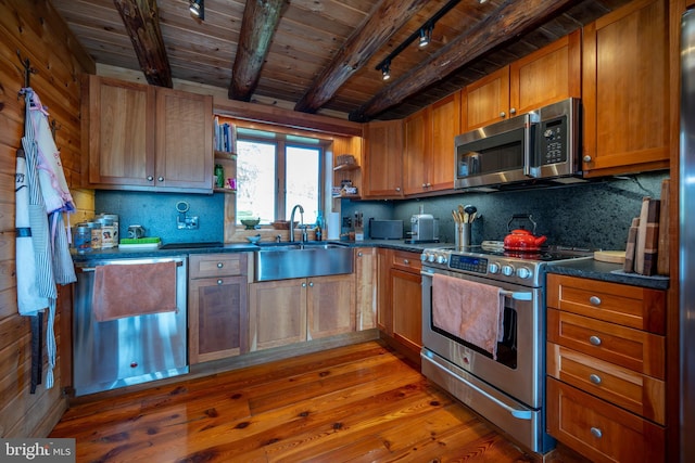 kitchen featuring stainless steel appliances, wood-type flooring, decorative backsplash, sink, and beamed ceiling