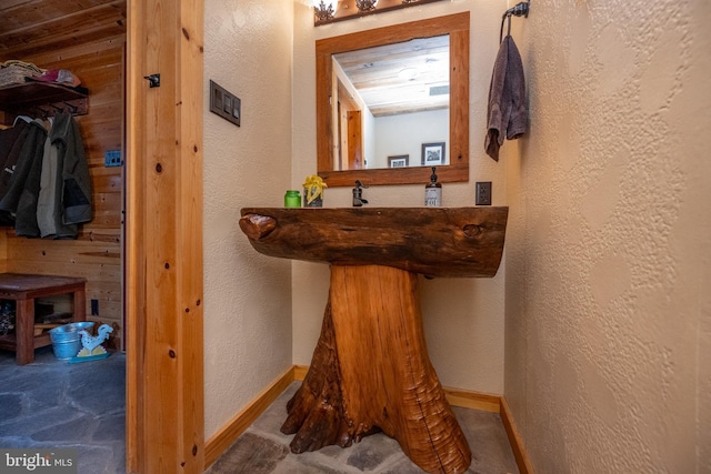 bathroom featuring wood walls