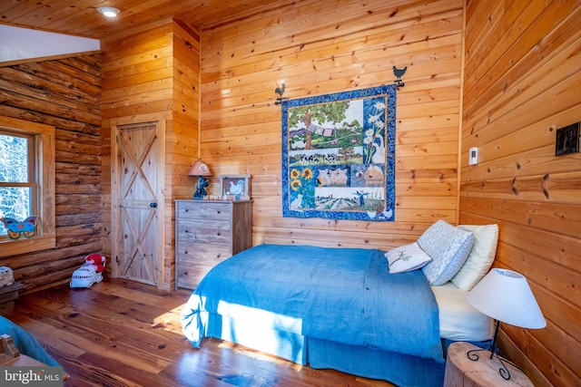 bedroom with wood walls, hardwood / wood-style floors, and wooden ceiling