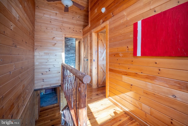 stairs with hardwood / wood-style flooring and wooden walls