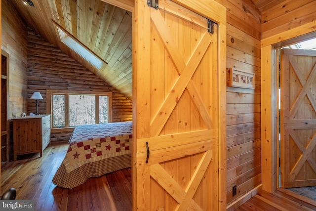 bedroom with wood walls, hardwood / wood-style flooring, and lofted ceiling with skylight