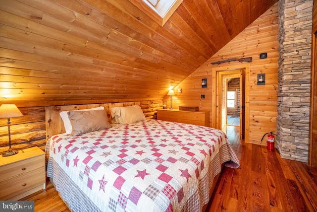 bedroom with hardwood / wood-style floors, wooden walls, vaulted ceiling with skylight, and wooden ceiling