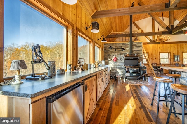 kitchen featuring dark hardwood / wood-style flooring, beamed ceiling, a wood stove, and high vaulted ceiling