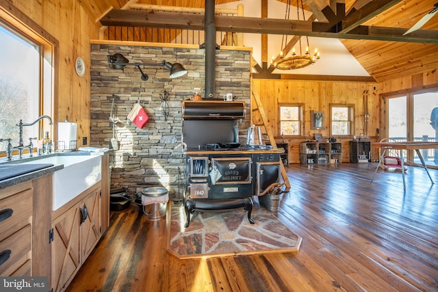 living room with wood walls, beamed ceiling, dark wood-type flooring, and a notable chandelier