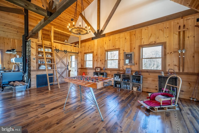 miscellaneous room with beamed ceiling, high vaulted ceiling, wood-type flooring, a chandelier, and a barn door