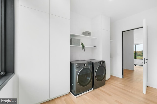 laundry room featuring separate washer and dryer and light hardwood / wood-style flooring