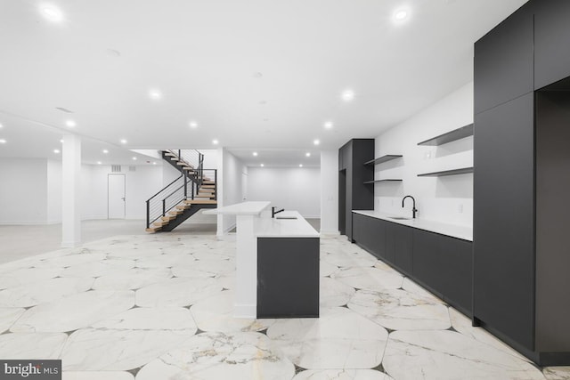 kitchen featuring sink and an island with sink