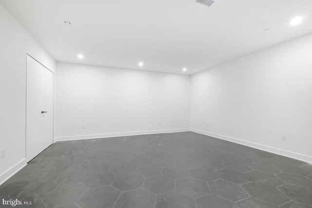 unfurnished room featuring dark tile patterned floors