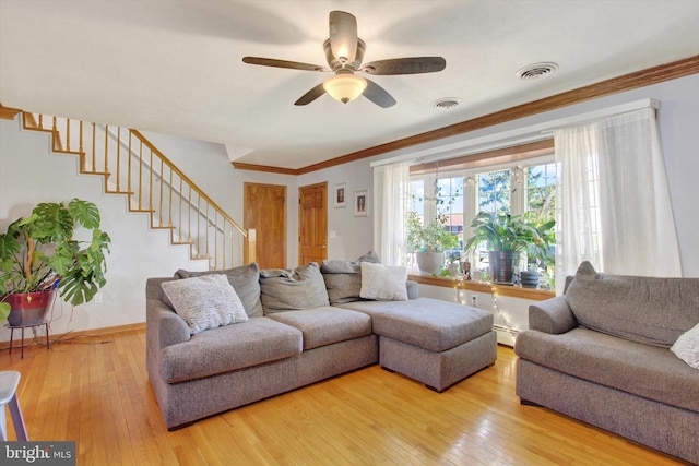 living room with ceiling fan, wood-type flooring, a baseboard heating unit, and ornamental molding