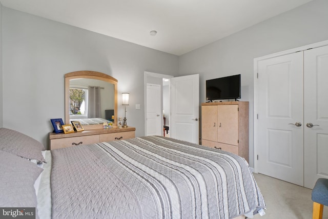 bedroom featuring light carpet and a closet