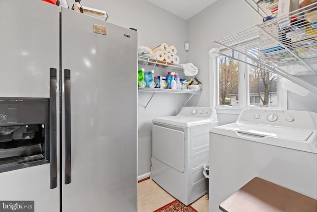 laundry room with washing machine and dryer and light tile patterned flooring