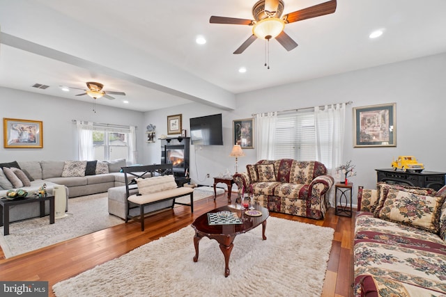 living room featuring hardwood / wood-style floors and ceiling fan