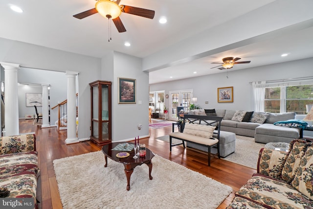 living room with decorative columns, hardwood / wood-style flooring, and ceiling fan