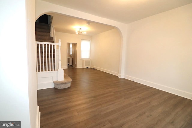 spare room featuring dark wood-type flooring and radiator