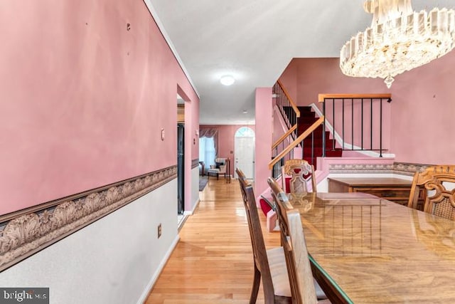 dining room with light hardwood / wood-style floors and a notable chandelier