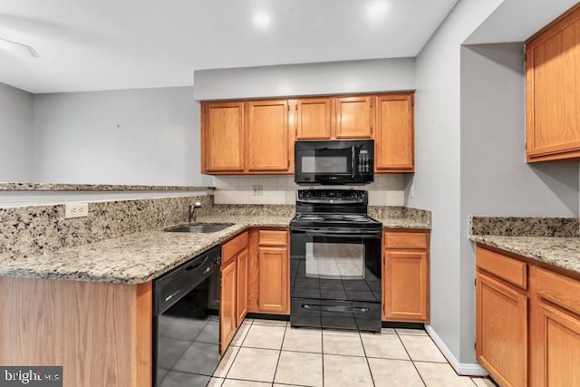 kitchen featuring light tile patterned floors, light stone countertops, sink, and black appliances