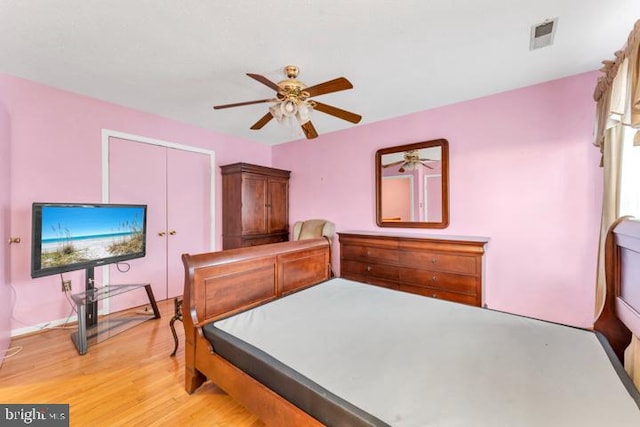 bedroom with light hardwood / wood-style floors, ceiling fan, and a closet