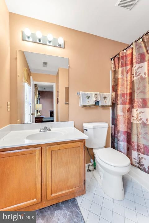 full bathroom featuring toilet, shower / bath combo, vanity, and tile patterned floors