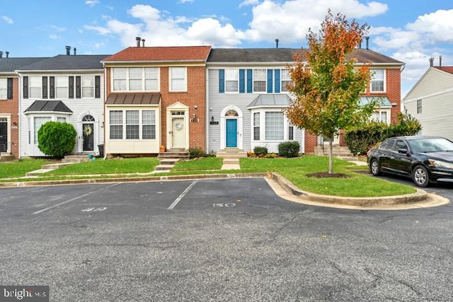 townhome / multi-family property with a front lawn