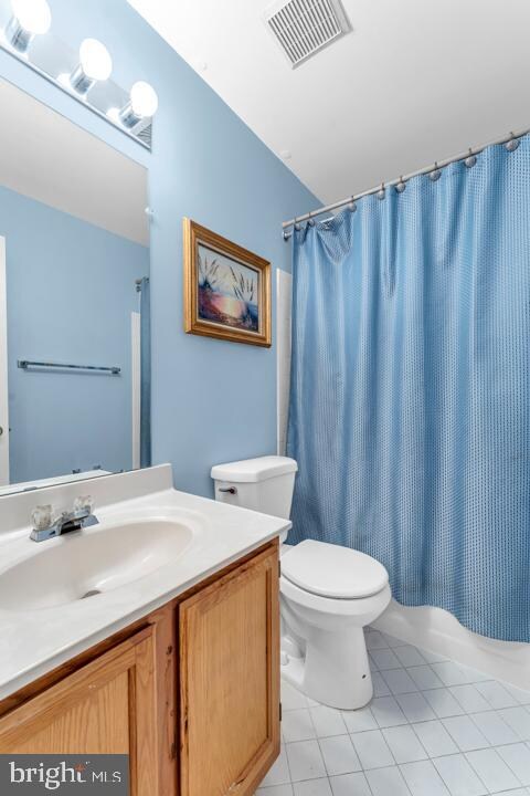 full bathroom with tile patterned flooring, vanity, toilet, and shower / tub combo