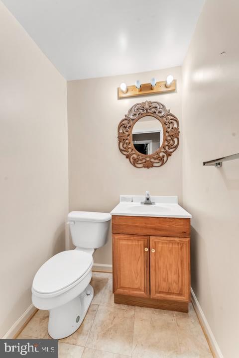 bathroom with toilet, vanity, and tile patterned floors