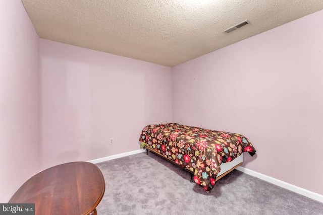 bedroom featuring a textured ceiling and carpet floors