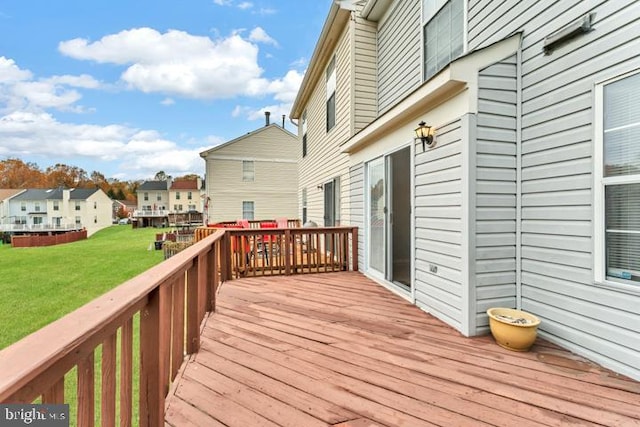 wooden deck featuring a lawn