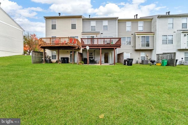 back of house with a wooden deck, cooling unit, and a lawn