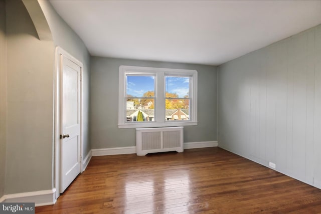 unfurnished room featuring dark wood-type flooring and radiator