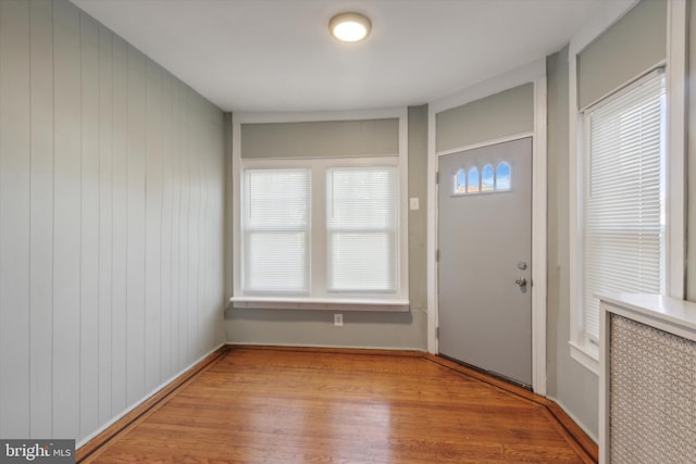 entrance foyer featuring light hardwood / wood-style floors and wood walls