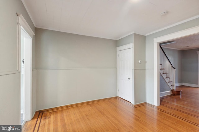 unfurnished room featuring ornamental molding and hardwood / wood-style flooring