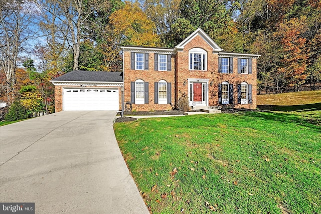 colonial house featuring a front lawn and a garage